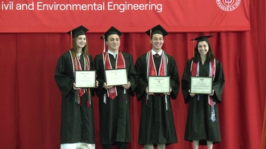 Graduates holding their diplomas.